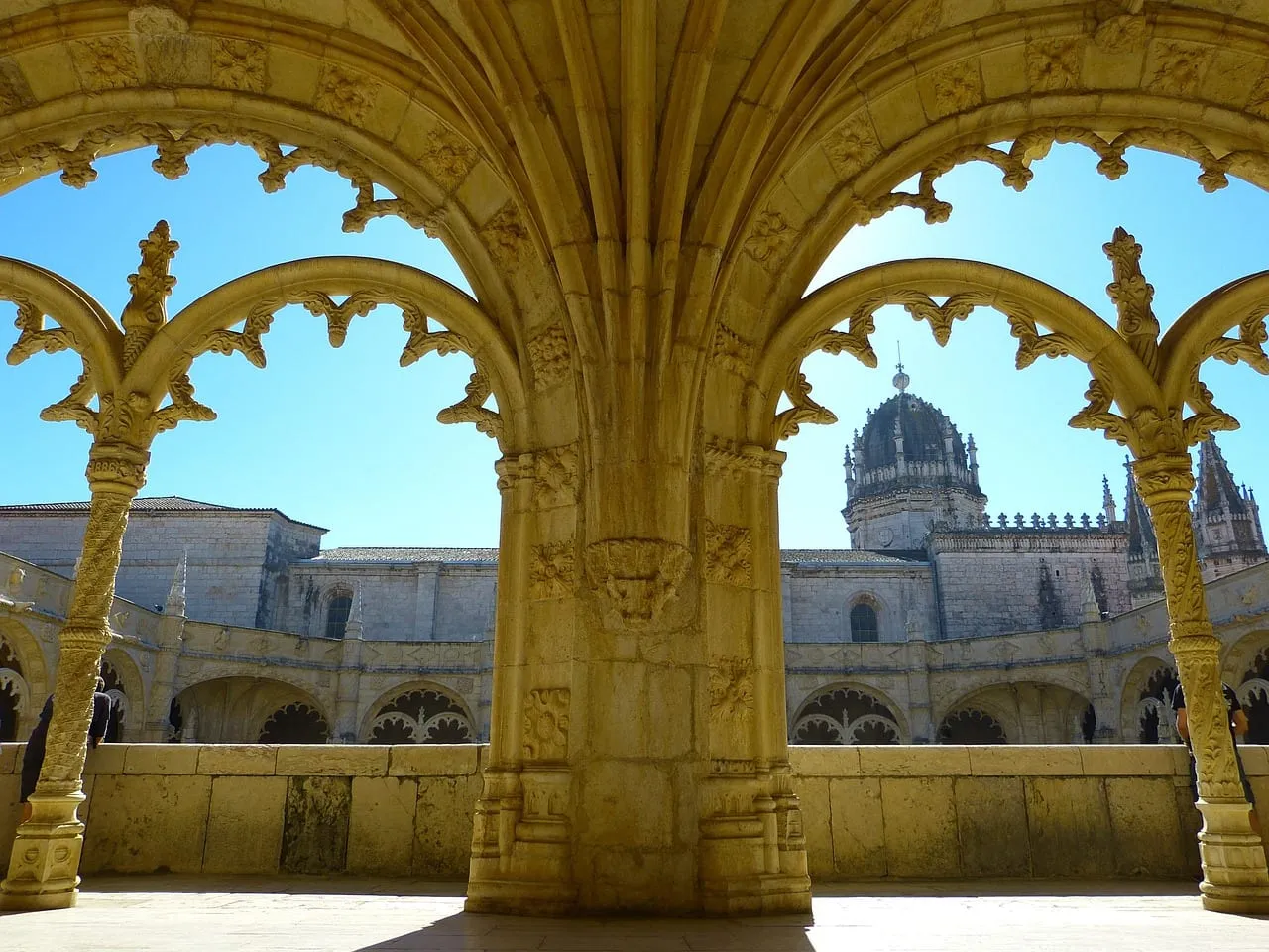 El claustro visto a través de un arco tallado, con la cúpula detrás