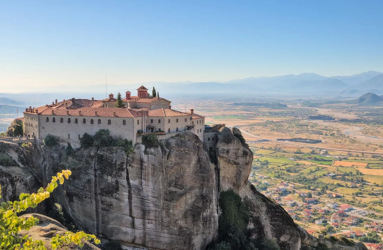Un monasterio en lo alto de un acantilado, con la llanura a sus pies