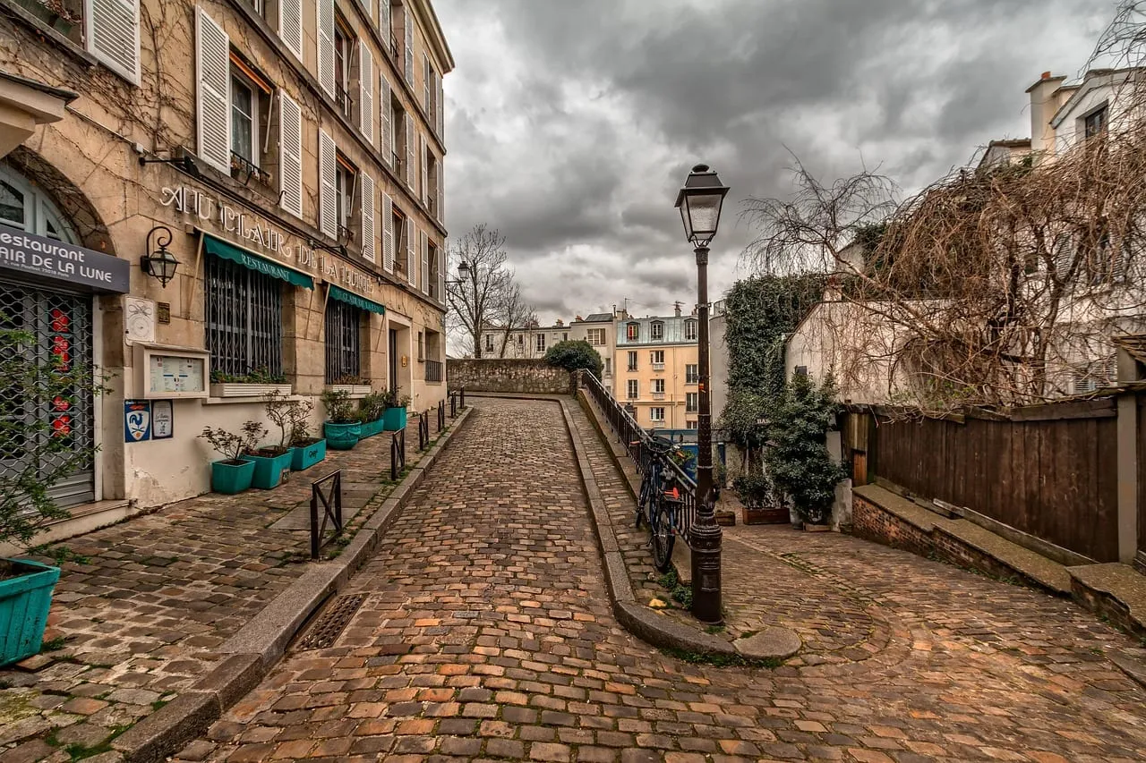 Un callejón empedrado de Montmartre con farolas y casas antiguas