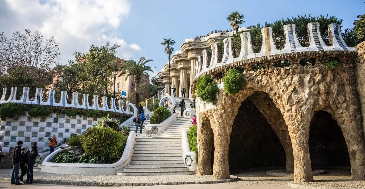 La escalinata principal con muros de azulejos blancos, palmeras y la terraza arriba