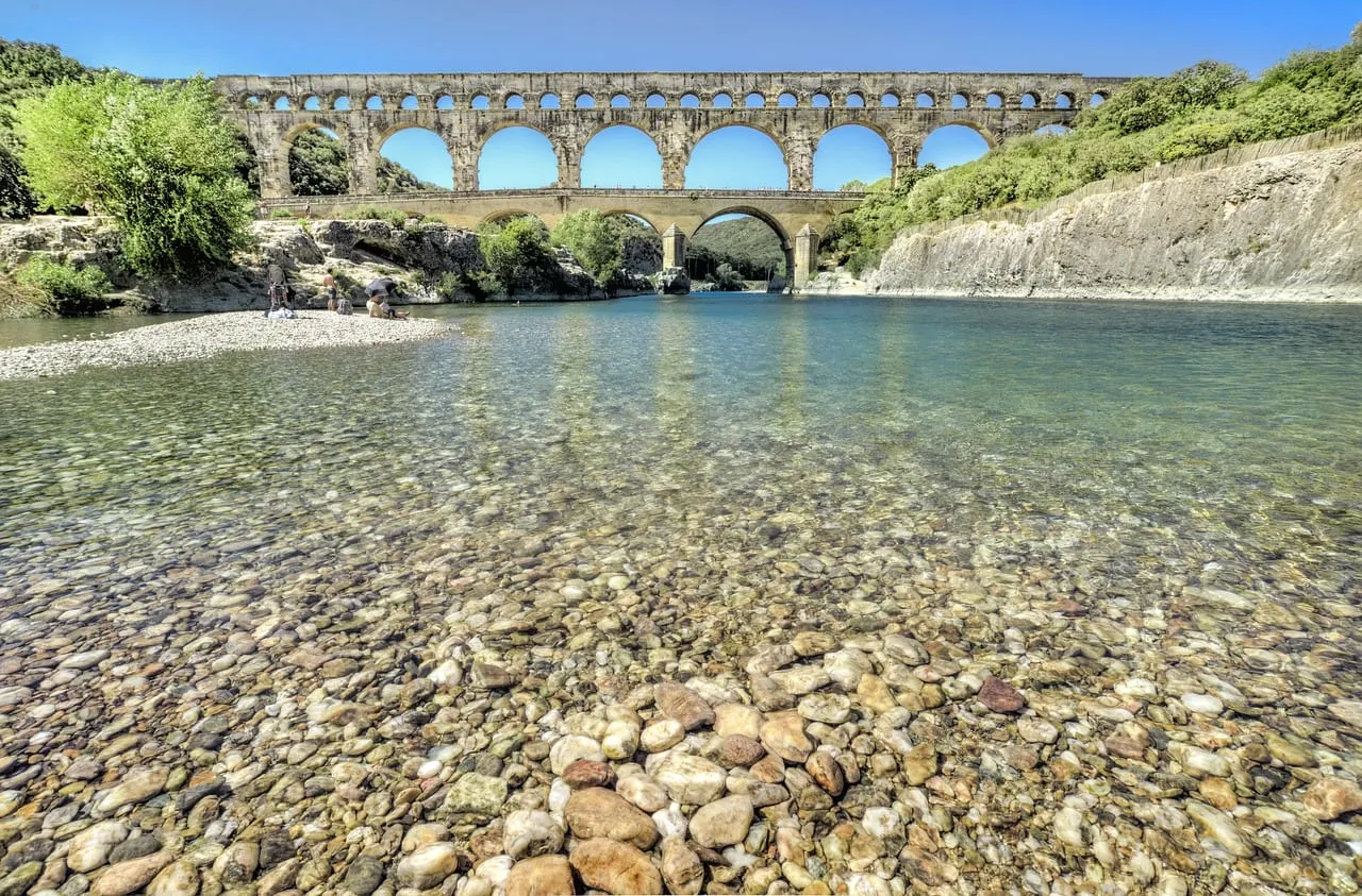 El Gardon, claro y poco profundo, con el puente a lo lejos
