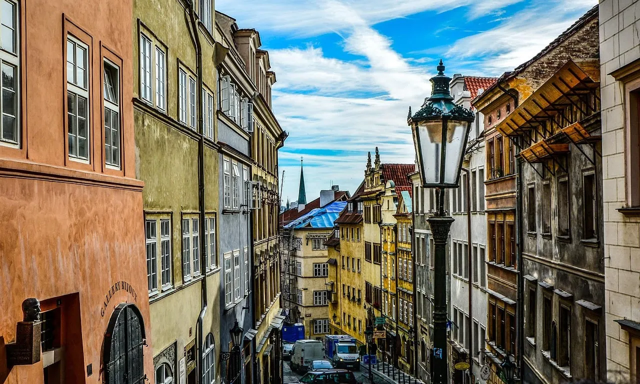 Una calle estrecha de casas antiguas con una farola en la Ciudad Vieja de Praga