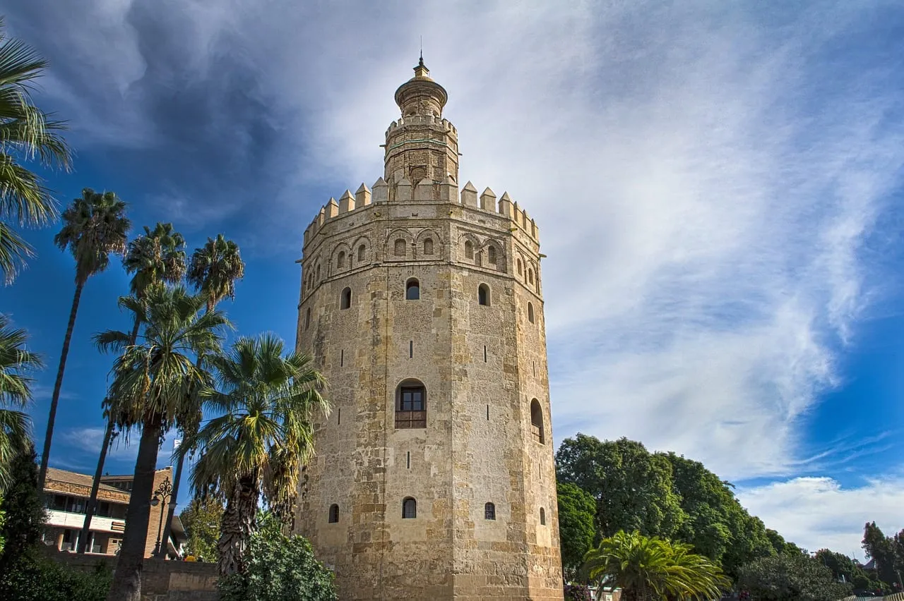 La Torre del Oro junto al Guadalquivir, enmarcada por palmeras