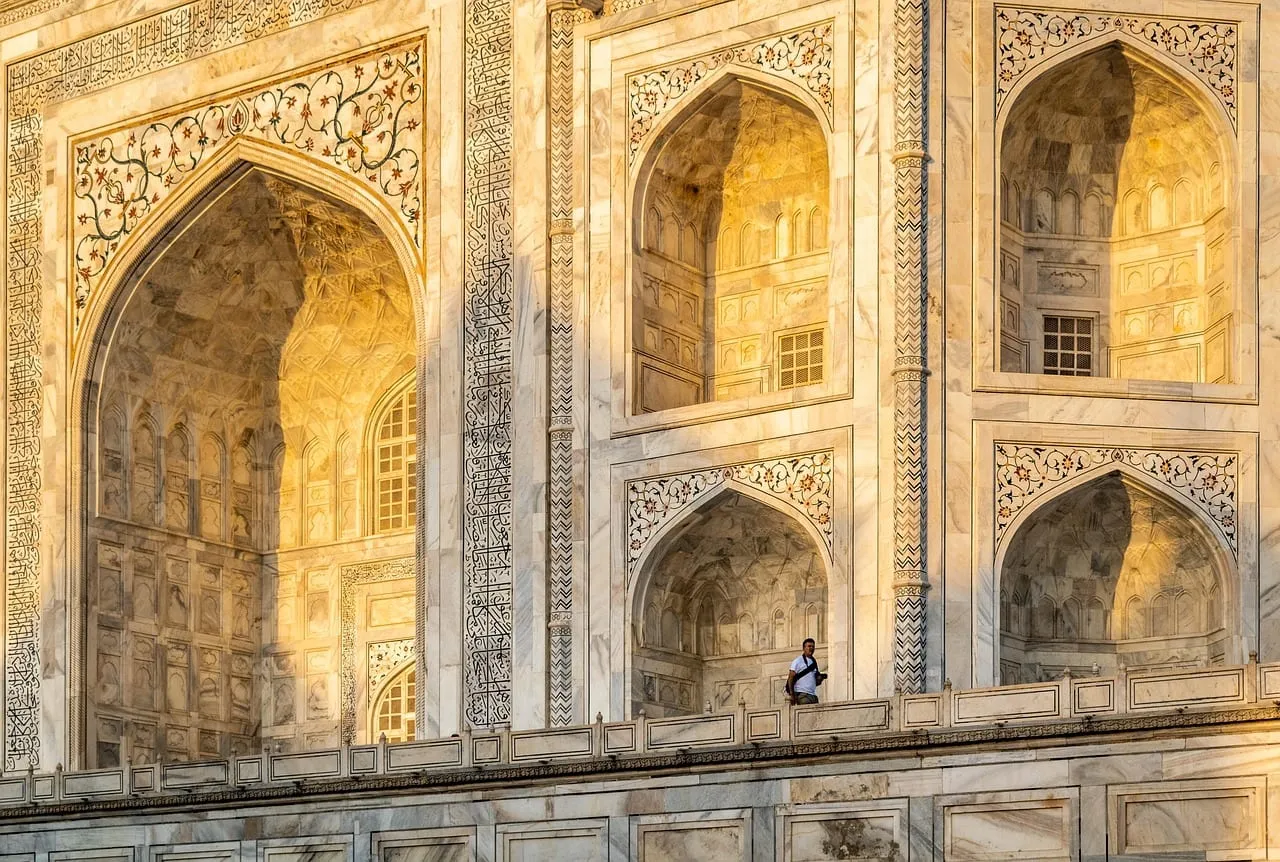Arcos de mármol tallados del Taj Mahal con luz cálida